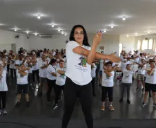 Instrutora realizando atividades físicas com os idosos.