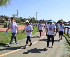 Idosos realizando a caminhada no lago.
