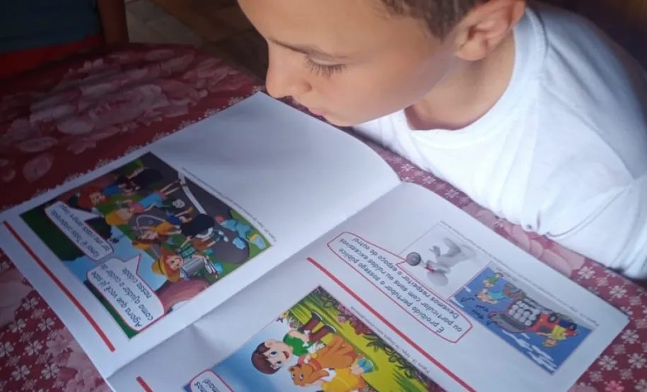 Aluno fazendo a leitura da Cartilha