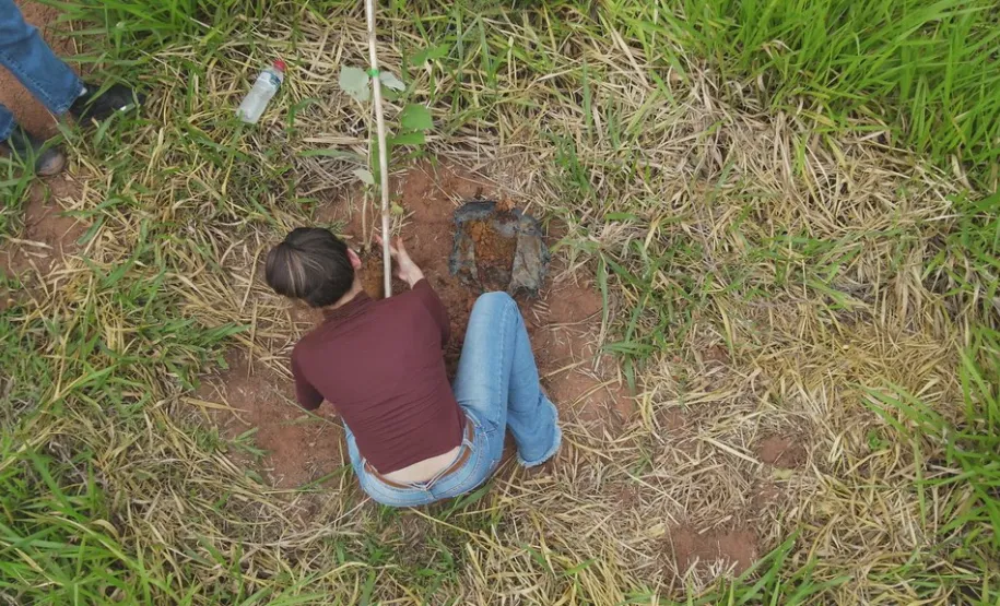 Estudante auxiliando no plantio