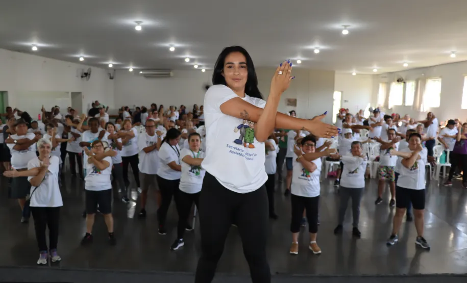 Instrutora realizando atividades físicas com os idosos.