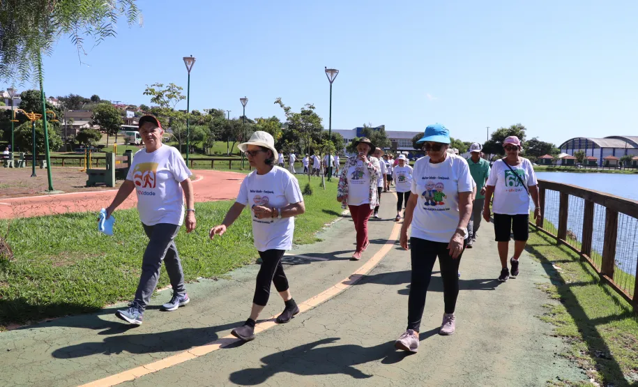 Idosos realizando a caminhada no lago.