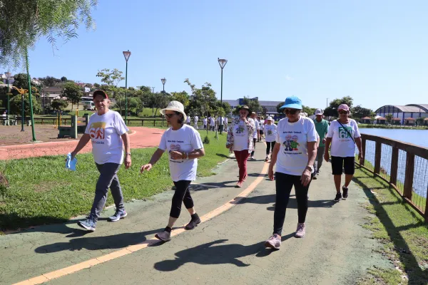 Idosos realizando a caminhada no lago.