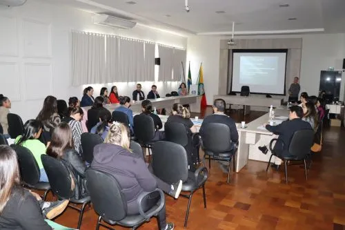 Profissionais reunidos discutindo condutas e fluxos no atendimento a casos de violência infantil.